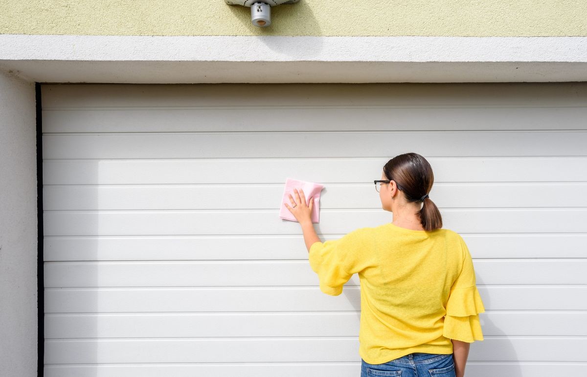 young woman or girl cleaning garage door pvc