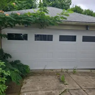 Residential garage door with top window section