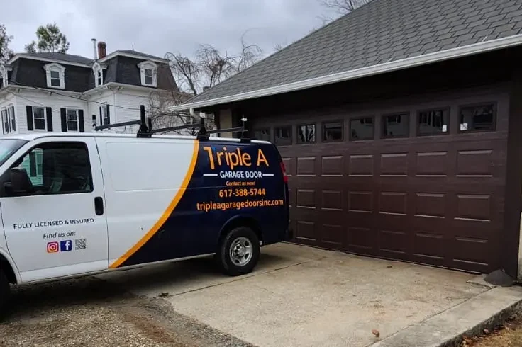 Triple A Garage Doors van beside modern brown garage door installation project in Massachusetts